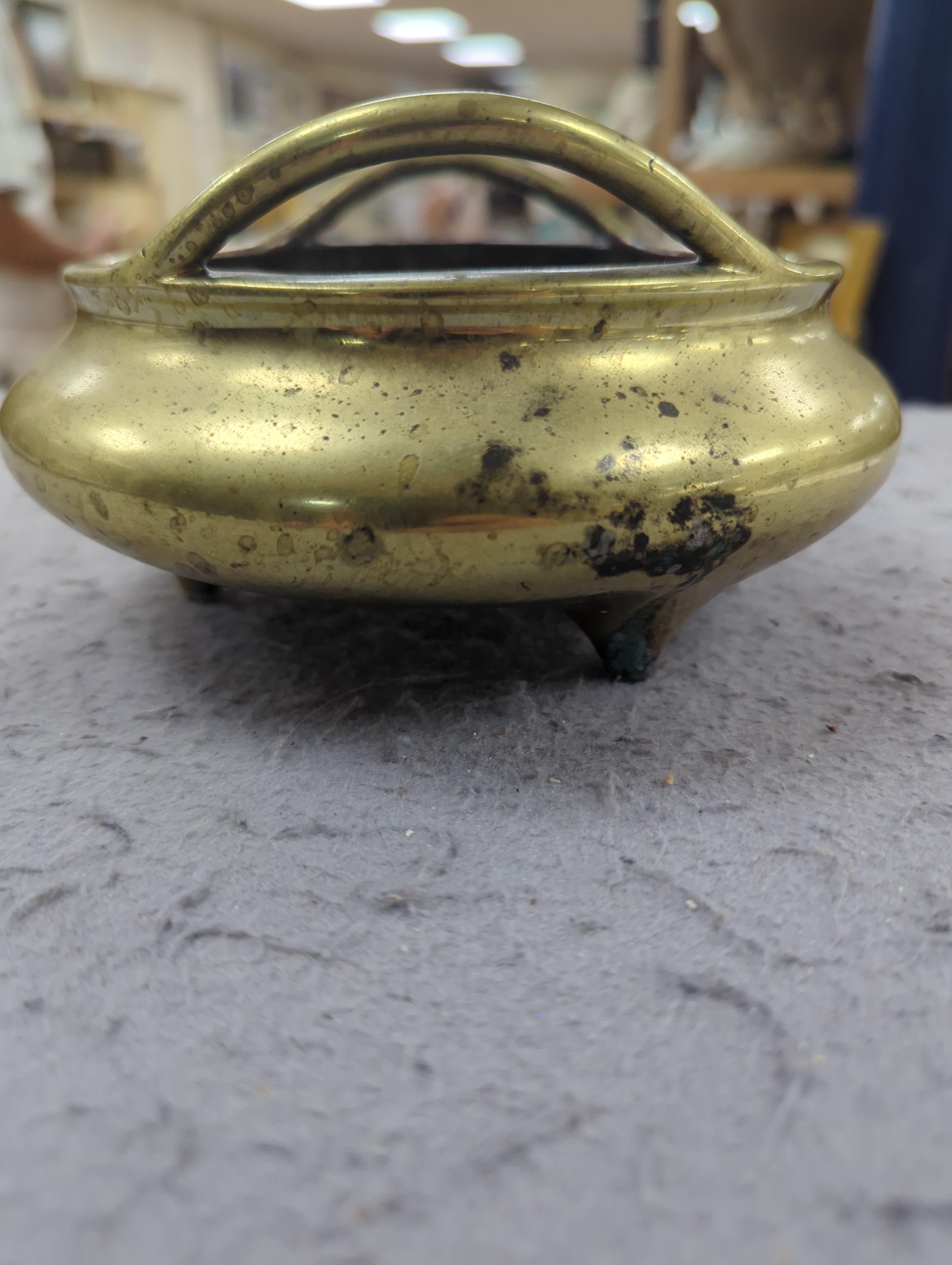 A late 19th century Chinese bronze censer with twin handles, apocryphal Xuande mark, 17.5cm in diameter